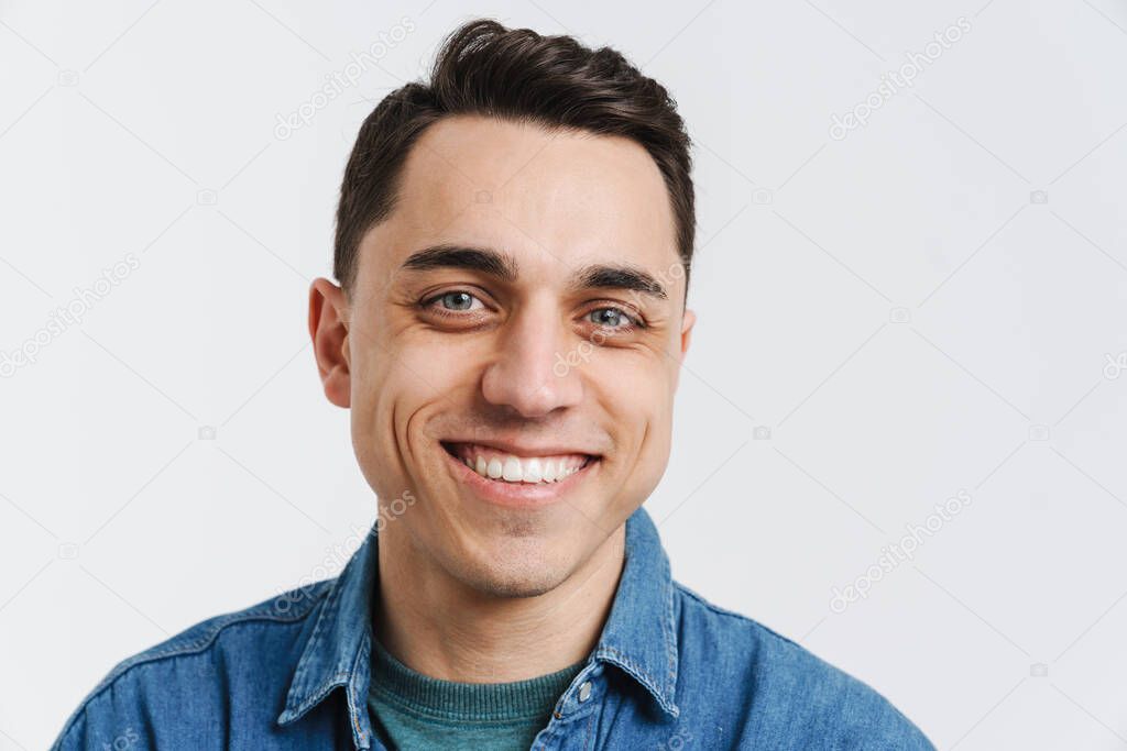 Young brunette man smiling and looking at camera isolated over white background