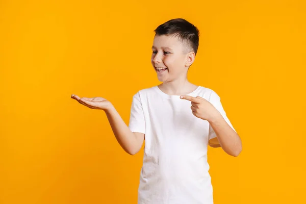 Feliz Niño Preadolescente Sonriente Camiseta Pie Sobre Fondo Amarillo Presentando —  Fotos de Stock