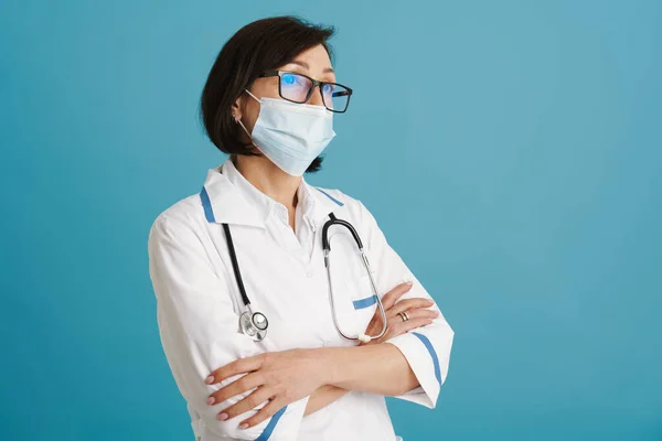 Evropský Zralý Lékař Masce Pózuje Stetoskopem Izolovaným Přes Modrou Stěnu — Stock fotografie