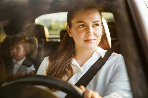 Joven Mujer Blanca Conduciendo Coche Mientras Hijo Sentado Asiento Del — Foto de Stock