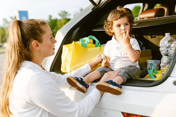 若いですホワイト女性遊びます彼女の息子とともに彼座っている間車のトランク — ストック写真