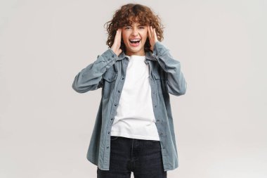 Genç kızıl, gülen ve kafasını beyaz arka planda tutan heyecanlı bir kadın.