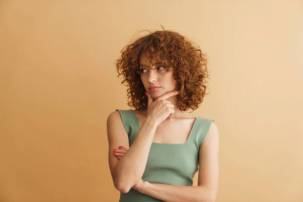 Jong Gember Krullend Vrouw Poseren Kijken Naar Camera Geïsoleerd Beige — Stockfoto