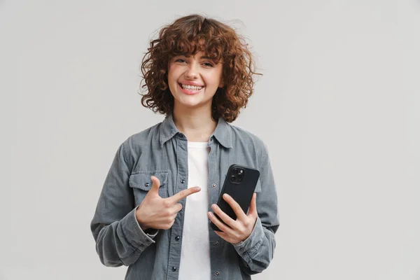 Mladá Vzrušená Žena Drží Ukazuje Prstem Mobilní Telefon Izolované Přes — Stock fotografie