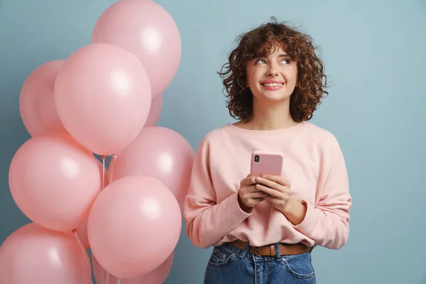 Молодая Рыжая Счастливая Женщина Помощью Мобильного Телефона Позируя Розовыми Шариками — стоковое фото