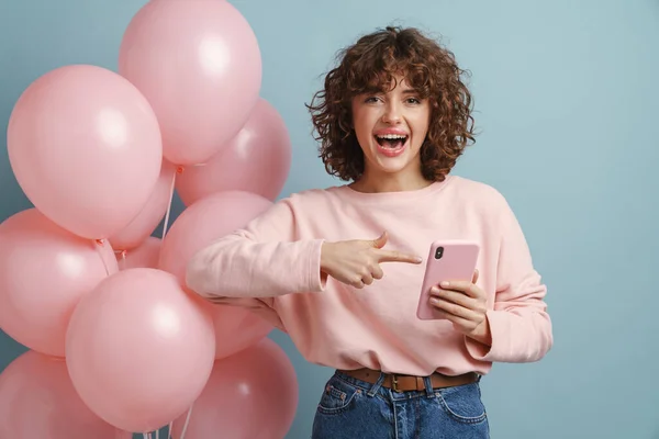 Захоплена Жінка Спрямовує Палець Свій Мобільний Телефон Позує Рожевими Кульками — стокове фото