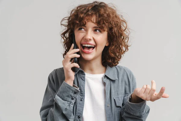 Молодая Веселая Женщина Жестикулирует Разговаривая Мобильному Телефону Изолированы Белом Фоне — стоковое фото
