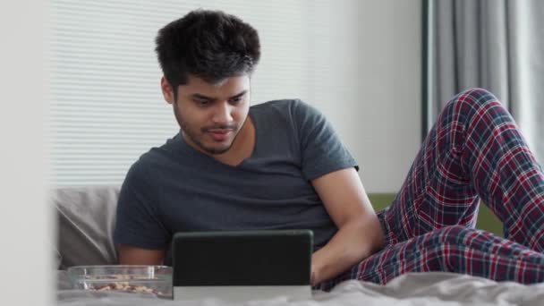 Smilende Indisk Mand Iført Pyjamas Taler Ved Videoopkald Tabletten Spiser – Stock-video