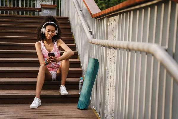 Mujer Negra Usando Teléfono Móvil Auriculares Mientras Está Sentada Escaleras —  Fotos de Stock