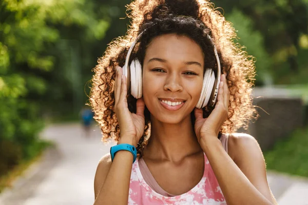 Mujer Negra Joven Escuchando Música Con Auriculares Durante Entrenamiento Parque —  Fotos de Stock