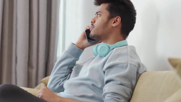 一个严肃的印度年轻人在家里用电话交谈 — 图库视频影像