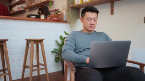 Konzentrierter Asiatischer Junger Mann Arbeitet Mit Laptop Café — Stockvideo