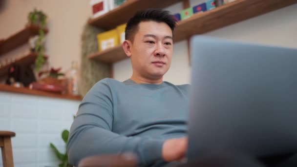 Lächelnder Asiatischer Junger Mann Arbeitet Mit Laptop Café — Stockvideo