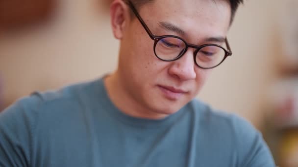 全神贯注的亚洲年轻人 戴着眼镜在咖啡店工作 — 图库视频影像