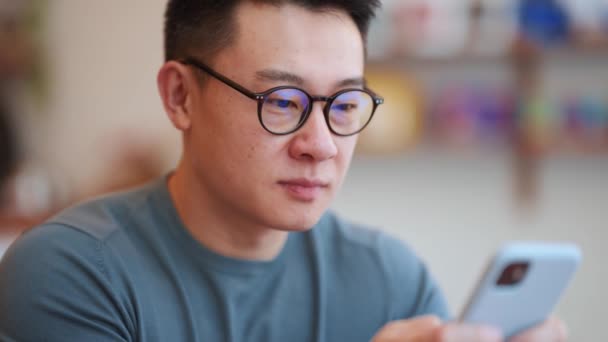 Glücklicher Asiatischer Junger Mann Mit Brille Telefoniert Café Sms — Stockvideo