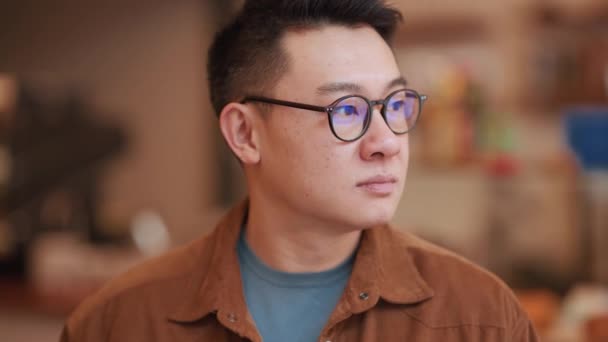 Vážný Asijský Mladý Muž Nosí Brýle Při Pohledu Kameru Kavárně — Stock video