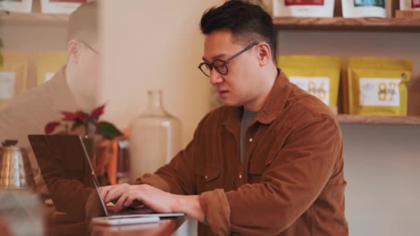 Meditative Asian Young Man Wearing Eyeglasses Texting Laptop Cafe — Stock Video