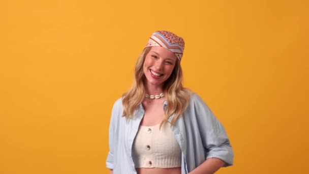 Leende Blond Kvinna Hippie Blinkar Vid Kameran Orange Studio — Stockvideo