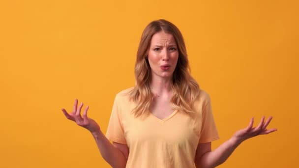Mujer Rubia Disgustada Con Camiseta Amarilla Tapando Orejas Estudio Naranja — Vídeo de stock