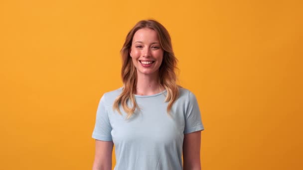 Glimlachende Blonde Vrouw Met Blauw Shirt Met Hartvormig Gebaar Naar — Stockvideo