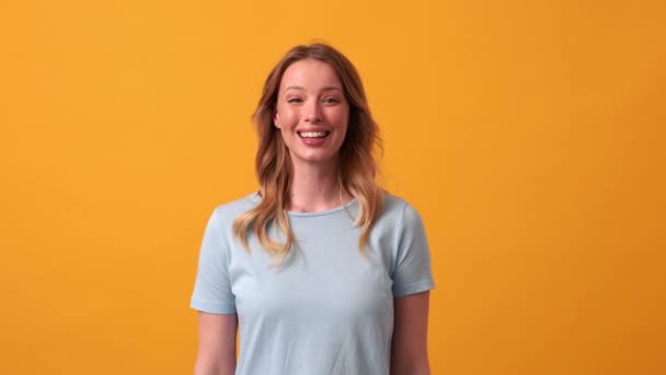 Mulher Loira Sorridente Vestindo Camiseta Azul Acenando Para Câmera Estúdio — Vídeo de Stock