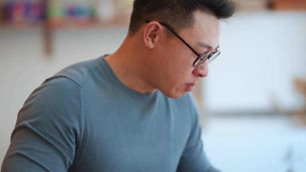 Usmívající Asijský Mladý Muž Nosí Brýle Jíst Jídlo Kavárně — Stock video