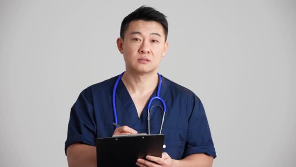 Довірливий Азіатський Лікар Збирає Анамнезис Сірій Студії — стокове відео