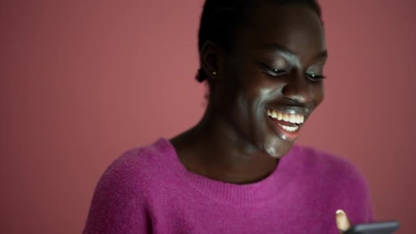 Zaskoczona Afrykanka Smsuje Przez Telefon Różowym Studio — Wideo stockowe