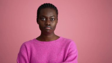 Mutlu Afrikalı kadın pembe stüdyoda el hareketi yapıyor.