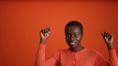 Turuncu stüdyoda dans eden güzel Afrikalı kadın.