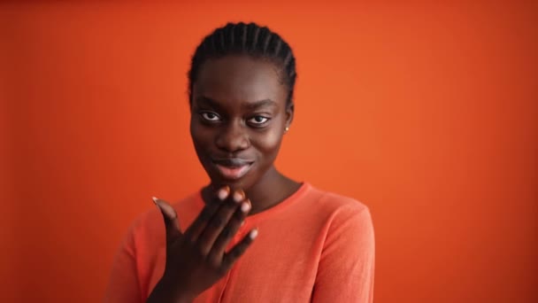 Pretty African Woman Blowing Air Kiss Camera Orange Studio — Stock Video