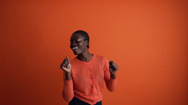 Позитивная Африканская Женщина Танцует Оранжевой Студии — стоковое видео