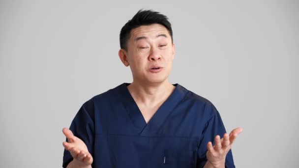 Flot Smilende Asiatisk Doktor Taler Noget Kameraet Det Grå Studie – Stock-video