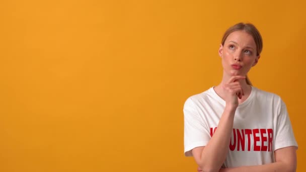 Femme Bénévole Pensive Pointant Vers Caméra Dans Studio Orange — Video