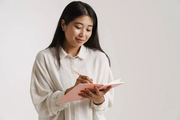 Mladá Asijská Žena Usmívá Při Psaní Poznámek Plánovači Izolované Přes — Stock fotografie