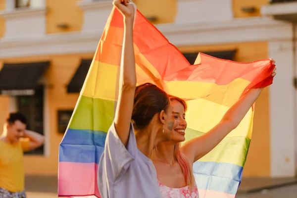 Unga Lesbiska Par Ler Och Går Med Regnbågsflagga Stolthet Parad — Stockfoto