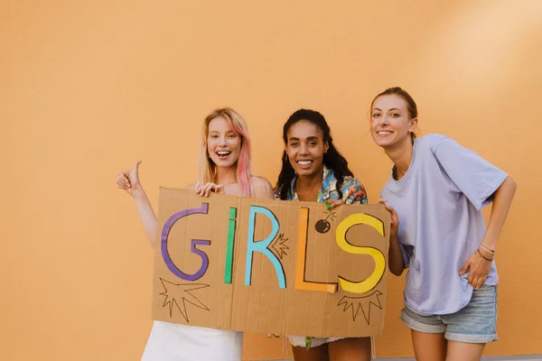 Young Lesbian Girls Smiling Holding Banner While Standing Yellow Wall — Foto Stock