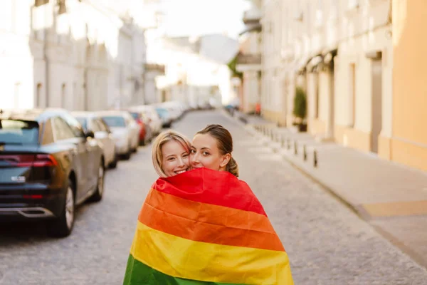 Young Lesbian Couple Rainbow Flag Hugging While Walking City Street —  Fotos de Stock