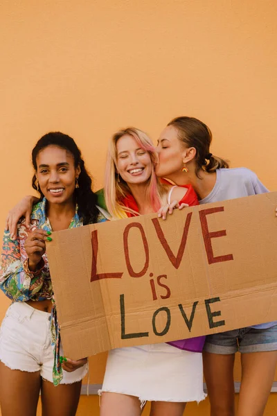 Young Lesbian Girls Smiling Holding Banner While Standing Yellow Wall —  Fotos de Stock