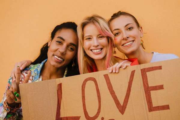 Young Lesbian Girls Smiling Holding Banner While Standing Yellow Wall — Foto Stock