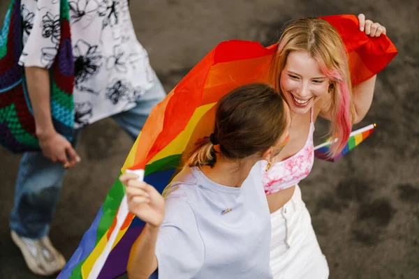Unga Lesbiska Par Ler Och Går Med Regnbågsflagga Stolthet Parad — Stockfoto
