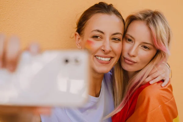 Young Lesbian Couple Smiling Taking Selfie Photo Yellow Wall — Zdjęcie stockowe