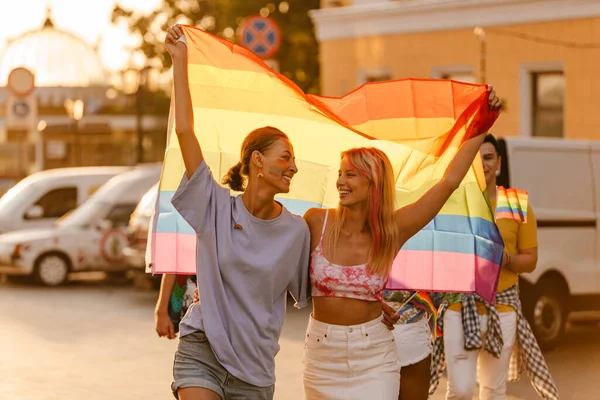Joven Pareja Lesbiana Caminando Con Banderas Arco Iris Durante Desfile —  Fotos de Stock