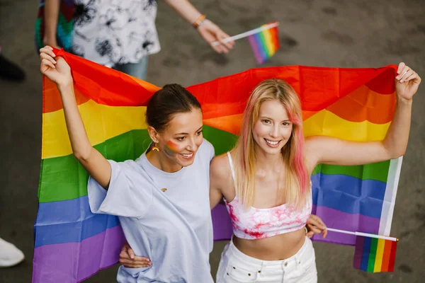 Mladé Lesbičky Pár Chůze Duhovými Vlajkami Během Hrdosti Průvod Ulici — Stock fotografie