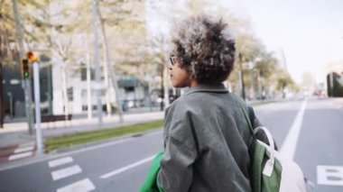 Arkaya bakan Afrikalı kadın dışarıda yürüyor.