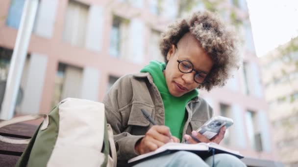 Konsantre Olmuş Yeşil Kapüşonlu Bir Afrikalı Kadın Dışarıdaki Akıllı Telefondan — Stok video