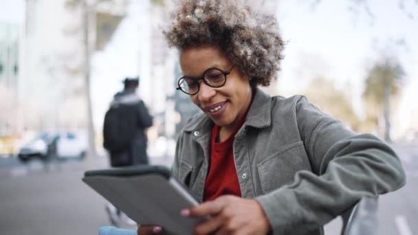 Smiling Adult African Woman Wearing Casual Clothes Looking Tablet While — ストック動画