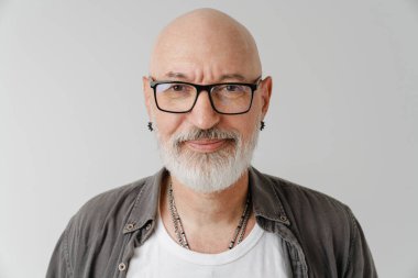 Gözlüklü kel Avrupalı adam beyaz arka planda izole edilmiş kameraya bakıyor ve poz veriyor.