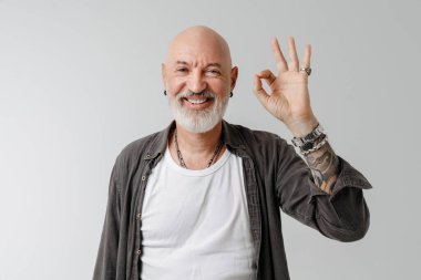 Beyaz arka planda izole edilmiş kameraya işaret ederken sakallı, gülen kel Avrupalı bir adam.