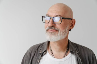 Gözlüklü kel Avrupalı adam beyaz arka planda izole edilmiş kameraya bakıyor ve poz veriyor.